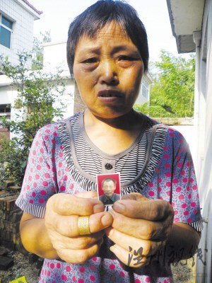 鮑祥義的妻子展示丈夫遺照。