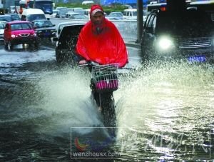 沖 潘家園橋下，一輛電動(dòng)車從積水中通過，水花飛濺。本報(bào)記者 尹亞飛 攝