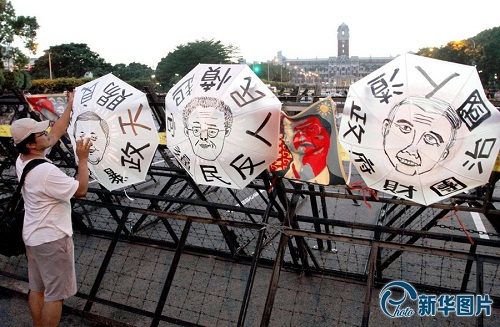 市民在雨傘上畫著領(lǐng)導(dǎo)人的畫像
